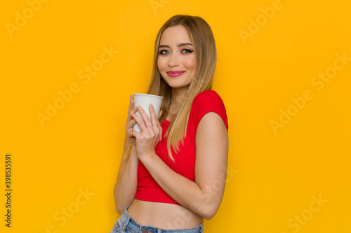 Young Woman In Red Top Is Holding White Cup And Smiling