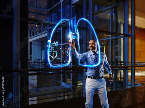 Male pulmonologist light painting lung in laboratory at hospital