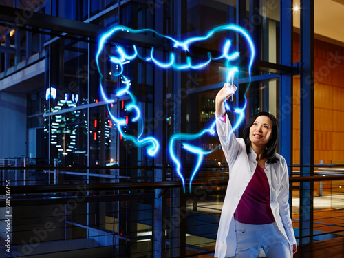 Female gastroenterologist analyzing large intestine with light painting at hospital