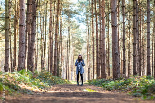 Female hiker exploring in Cannock Chase woodland during winter season