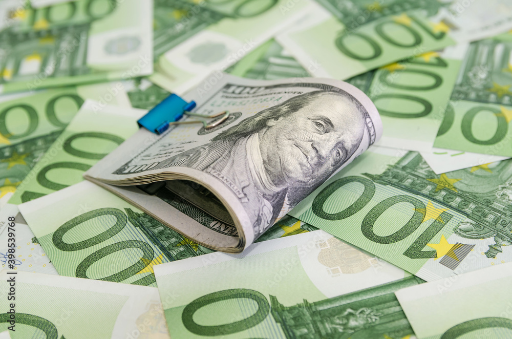 100 dollars squeezed with a metal clip on euro background, set of banknotes, European currency, 100 dollars squeezed with a metal clip on euro background, set of banknotes, European currency,