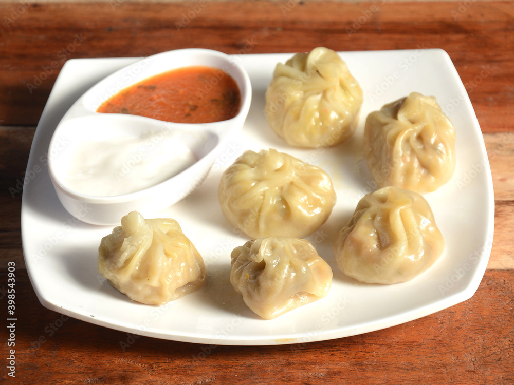Veg steam momo. Nepalese Traditional dish Momo stuffed with vegetables and then cooked and served with sauce and mayonnaise over a rustic wooden background, selective focus