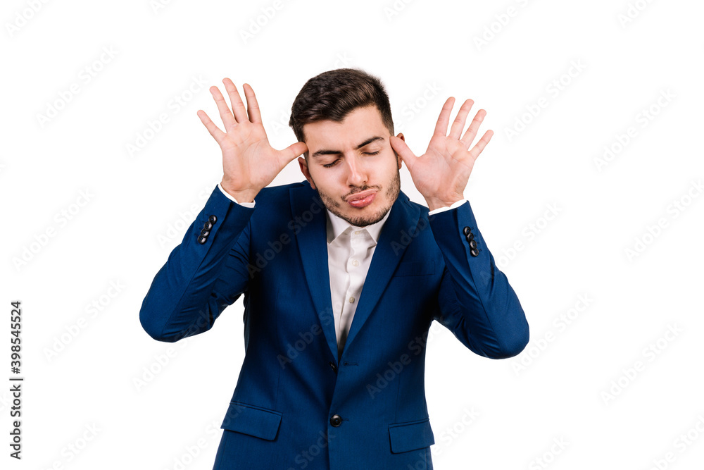 portrait on a white background of a young caucasian businessman with brunette hair making a funny expression with his hands and his face portrait on a white background of a young caucasian businessman with brunette hair making a funny expression with his hands and his face