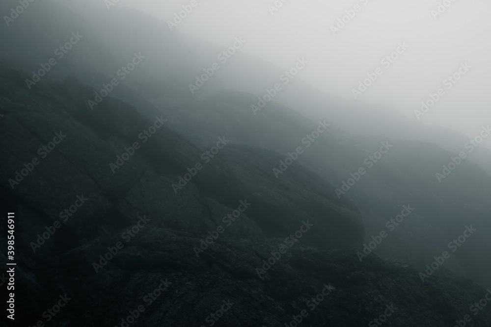 Black and white textured rock in the low clouds. Khibiny mountains, Kola Peninsula, Russia.