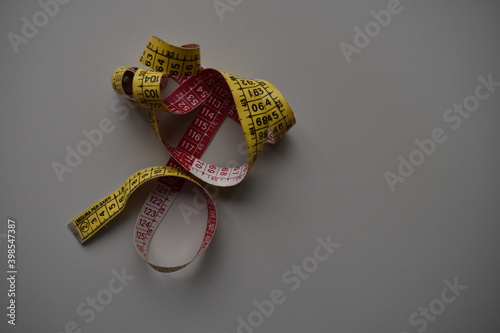 yellow-red tape measure on white background, tape measuring on white background, yellow-red tape on a white background with black numbers. selective focus