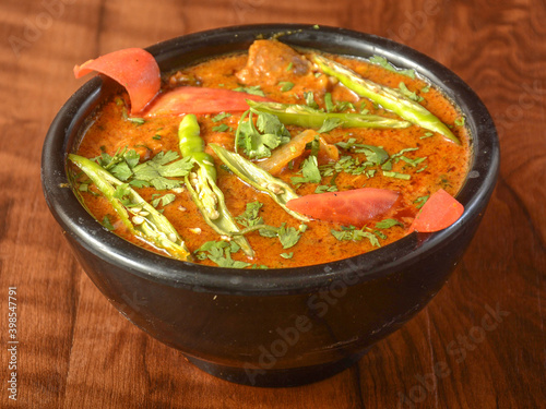Mutton handi or Lamb curry, spicy and delicious dish served over a rustic wooden background, selective focus