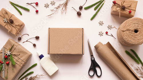 Step 1.Step by step instruction to eco friendly and zero waste Christmas gift wrapping.Gift box,brown paper,rope,glue,scissors and natural plants for decoration,top view,flat lay.