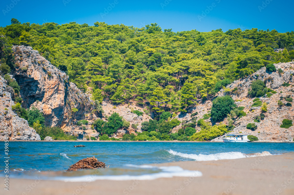 Turquoise waves of the sea on a sandy beach of turtles in the Dalyan Mugla region, Turkey.