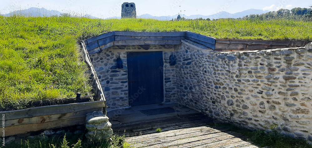 House or bunker built of stone underground with solid wood door and ...