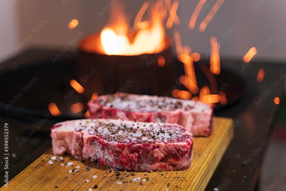 Carne de res corte new york grueso lista para poner en el asador con fuego  Stock Photo