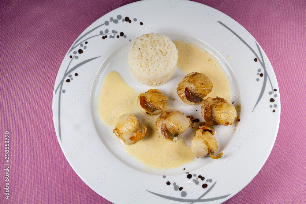 Plate of grilled scallops with rice and cream sauce Plate of grilled scallops with rice and cream sauce
