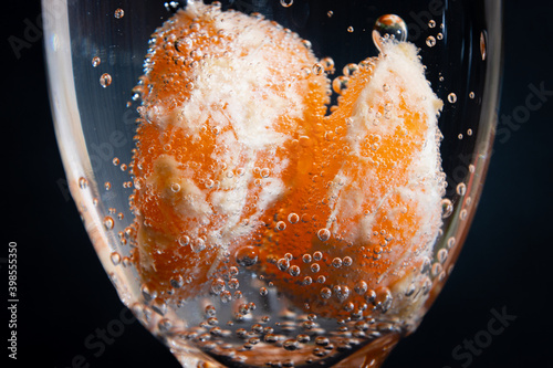 tangerine slices in a glass with gas bubbles