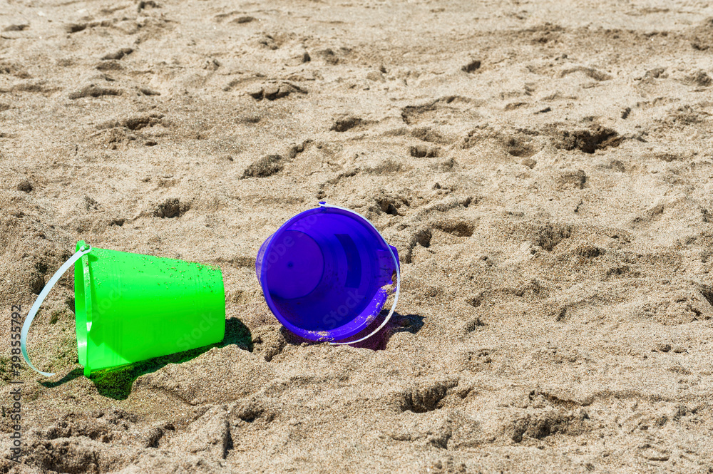 closeup of green and purple bucket on beach closeup of green and purple bucket on beach