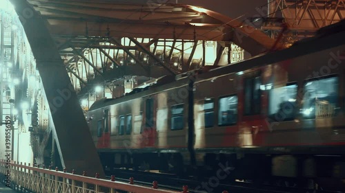 Train leaves goes over the Andreevsky bridge over the Moscow river in Moscow, Russia, in the evening of 27.11.2021