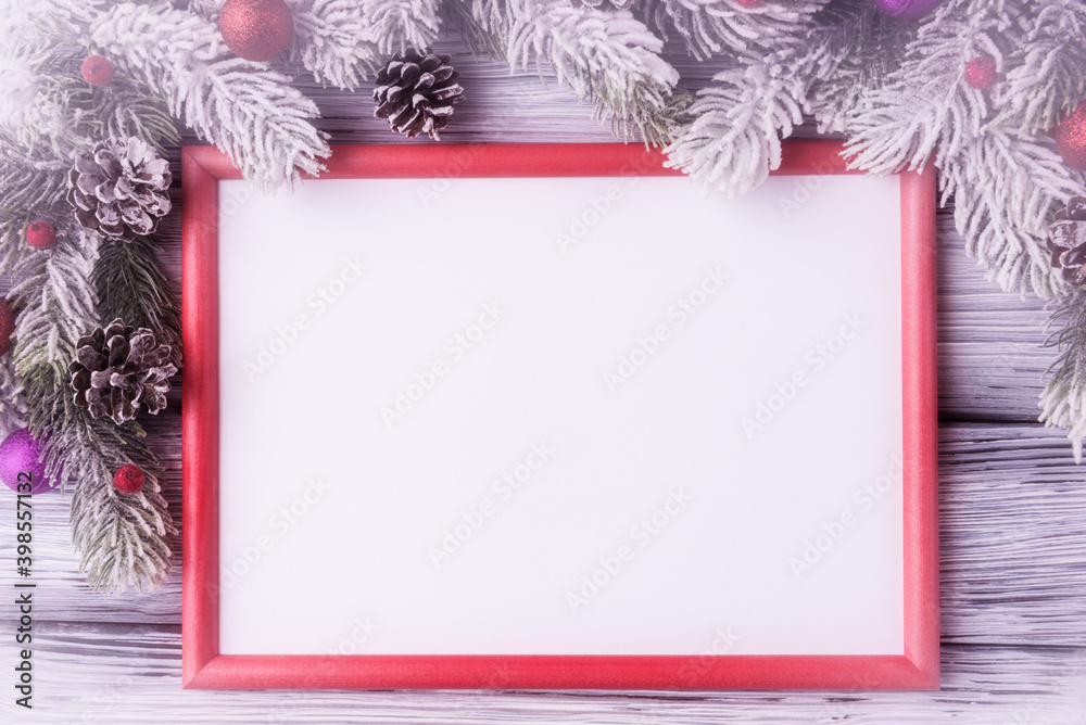 Fototapeta premium Mock up of red frame with blank white paper sheet in Christmas decoration