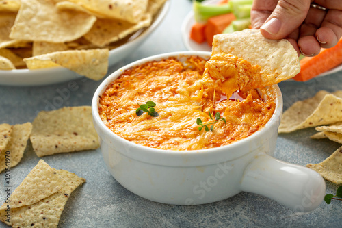 Buffalo chicken dip served with chips and fresh vegetables photo