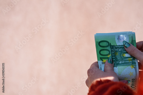 Hand couting holding and showing euro money or giving money. World money concept, 100 EURO banknotes EUR currency isolated with copy space. Concept of rich business people, saving or spending money. photo