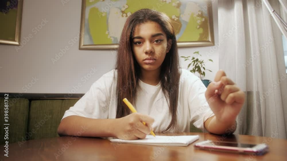 African american girl student looking at webcam of laptop making video call to online teacher. Concept distance education and e-learning during pandemic of coronavirus. African american girl student looking at webcam of laptop making video call to online teacher. Concept distance education and e-learning during pandemic of coronavirus.