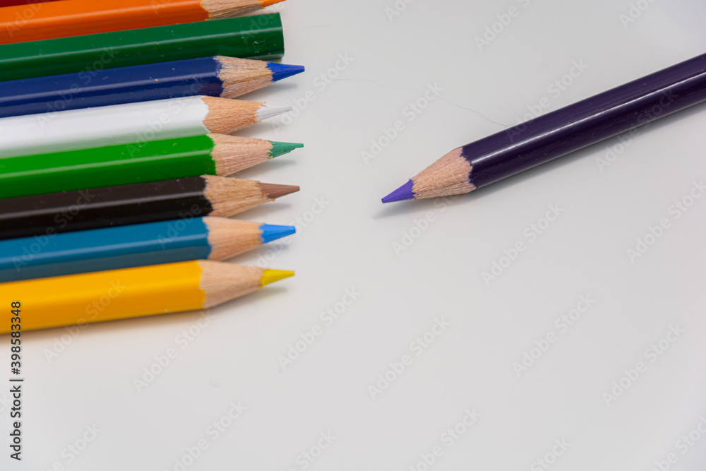 Pack of colorful pencils arranged to depict odd man out with a white background Pack of colorful pencils arranged to depict odd man out with a white background