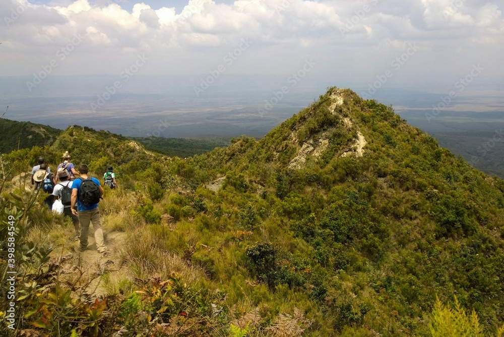 Rear view of a group of hikers against a scenic mountain landscape in rural Kenya