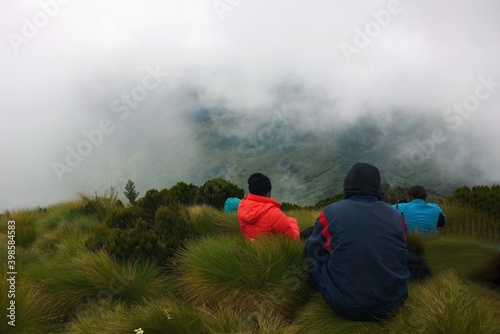 Rear view of a group of hikers at the top of a mountain against a foggy background in rural Kenya