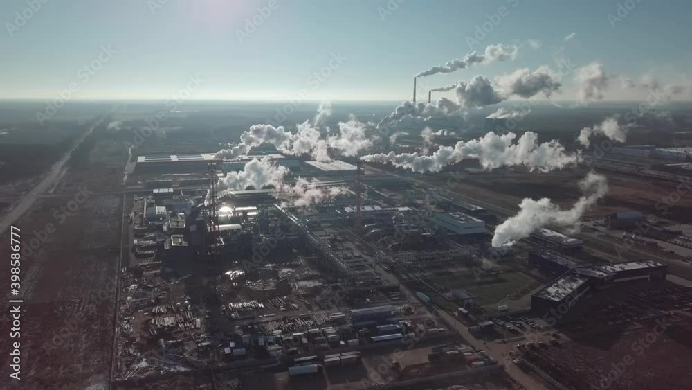 Aerial photography from a drone of pipes of factories and factories in front of the sun. The sun's rays highlight the terrible and gloomy smoke of pipes in the contour light. Aerial survey . Environme Aerial photography from a drone of pipes of factories and factories in front of the sun. The sun's rays highlight the terrible and gloomy smoke of pipes in the contour light. Aerial survey . Environme
