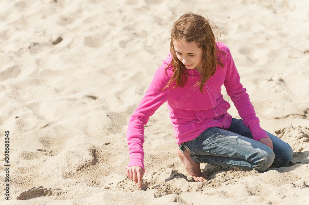 Preteen playing in sand on Oregon beach Preteen playing in sand on Oregon beach