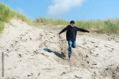 Boy running down a sand dune © Dee