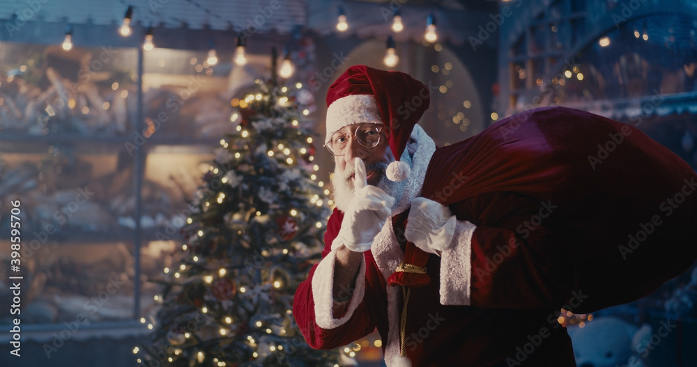 Happy Santa Claus walking quietly near Christmas tree