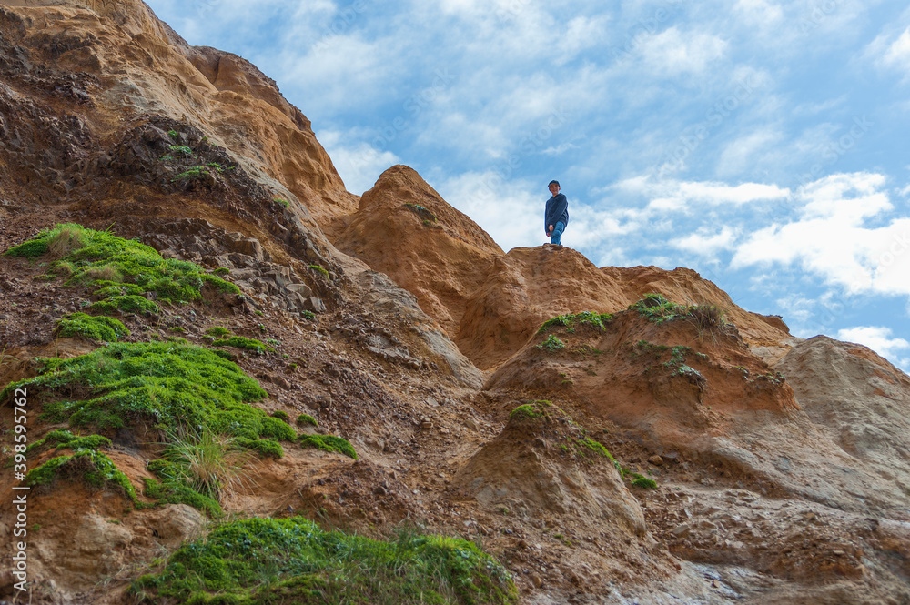 Boy explores the sandstone ledges at the base of the beach at Pacific City Oregon