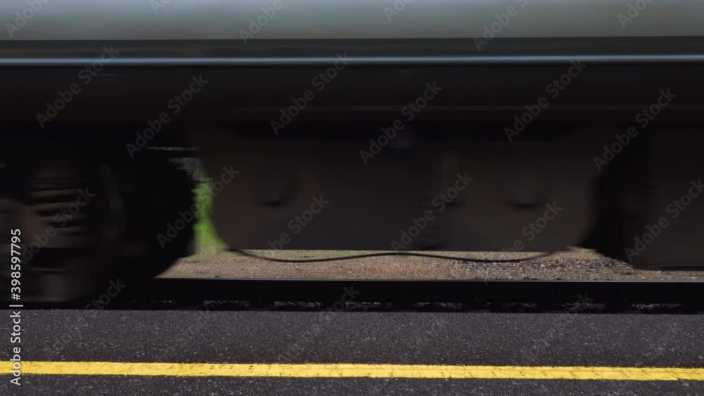 Train leaving on rail tracks in a rural area surrounded by nature. Public diesel train moving away from the platform. Train leaving on rail tracks in a rural area surrounded by nature. Public diesel train moving away from the platform.
