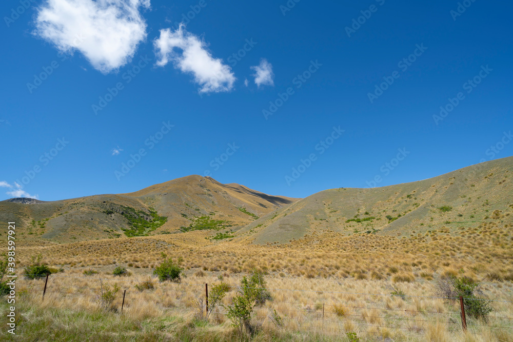 Peaks and tussock covered valleys of Lindis Pass, famous road trip. Peaks and tussock covered valleys of Lindis Pass, famous road trip.