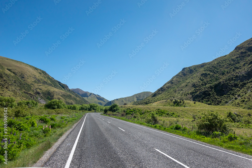 Fototapeta premium Highway stretches out ahead running between mountains.
