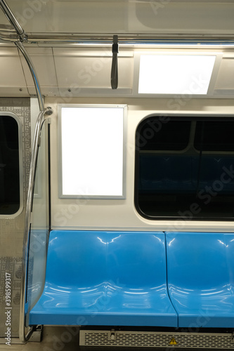 Blank advertising sign board template and television screen inside of subway. Empty and blue seat inside of subway. 