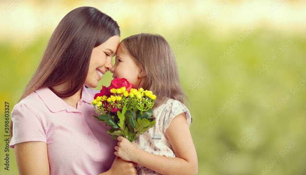 Mother and daughter with bouquet of flowers on blurred background. Mother and daughter with bouquet of flowers on blurred background.