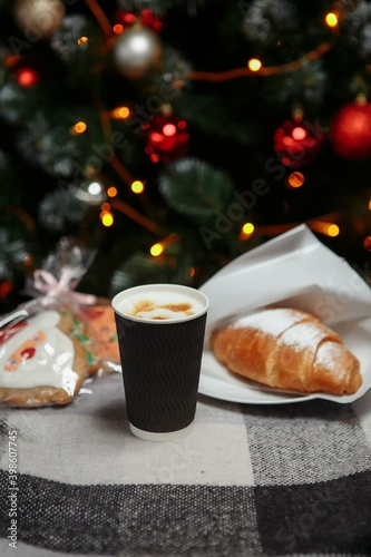 Christmas coffee and croissants with gifts and toys on the background of the Christmas tree