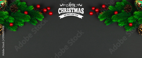 Christmas banner with green fir brunches and red berries on black background, top view, copy space, concept and design