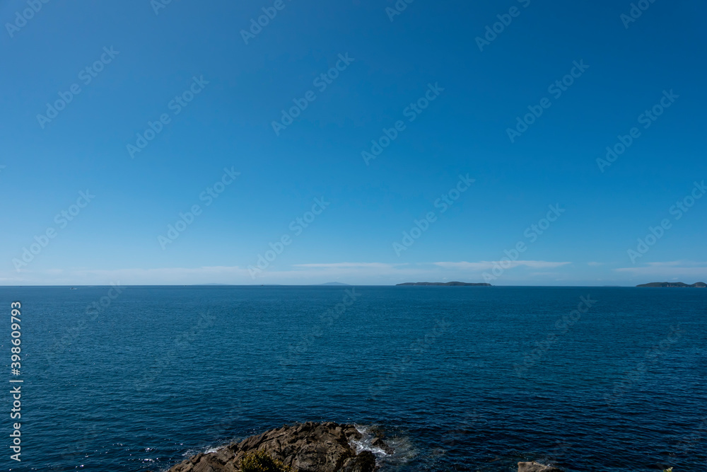 Blue backgound of sea to distant horizon under blue sky for nautical or travel backgrounds,