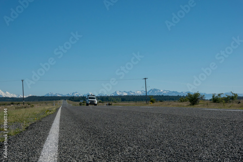 Southern Alps beyond vehicles traveling along rural highway