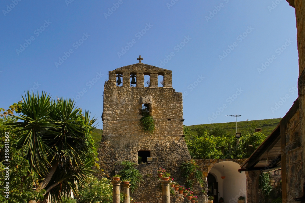 Stone bell tower of an ancient Orthodox church on the Peloponnese island (Greece)