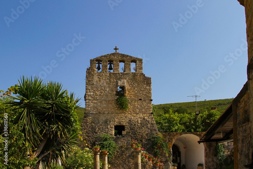 Stone bell tower of an ancient Orthodox church on the Peloponnese island (Greece)