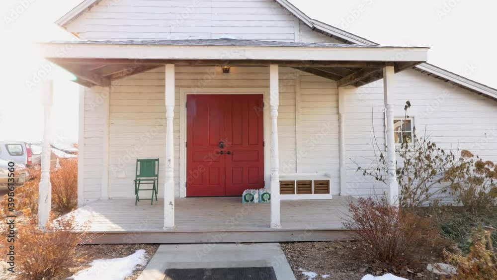 4K footage of a countryside house with a camera zooming in on the front porch in the winter.
