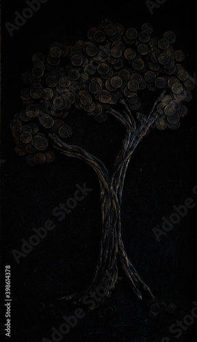 Dark picture with a wood made from coins and copper 