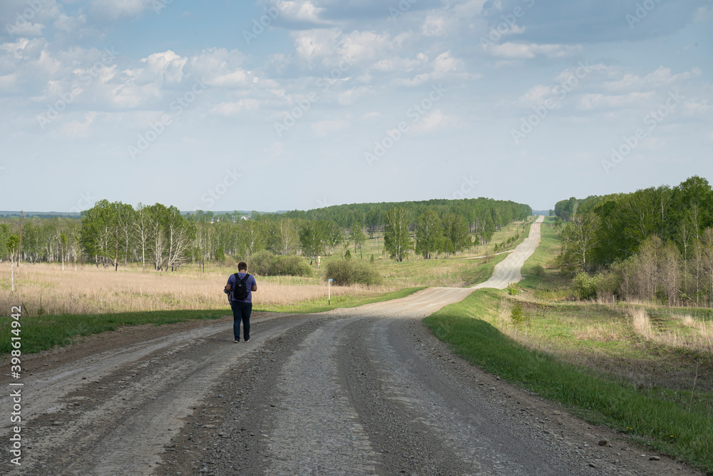 A man walks on a rural road A man walks on a rural road