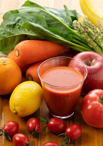 A variety of fruits and vegetables and a glass of vegetable juice