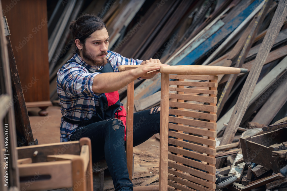 carpenter sand woodwork with sandpaper in furniture workshop