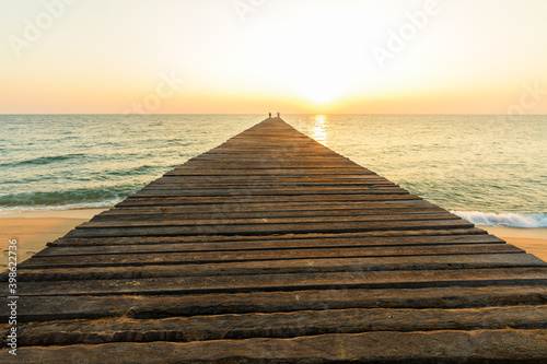 Fototapeta Naklejka Na Ścianę i Meble -  Wooden bridge on sea for entry to the beautiful ocean at sunset.
