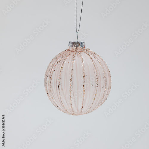 Fragile transparent Christmas tree ball with lengthwise glitter ornaments photo