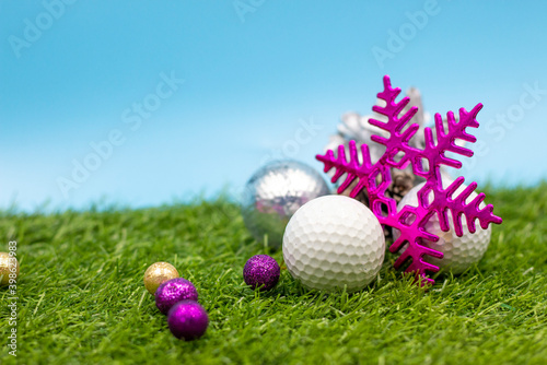 Golf Christmas Holiday with golf ball and Christmas Decoration on green grrass photo