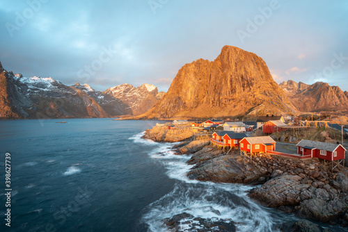 Landscape of red fishing rorbuer house village with sunrise light and mountain view in Lofoten island Hamnoy Norway